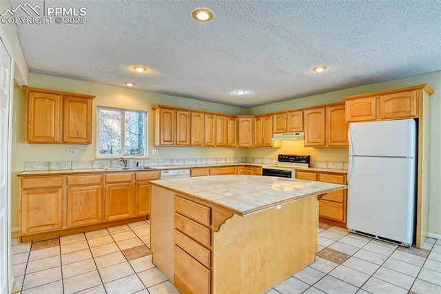 kitchen with a textured ceiling, tile counters, a kitchen island, and white appliances