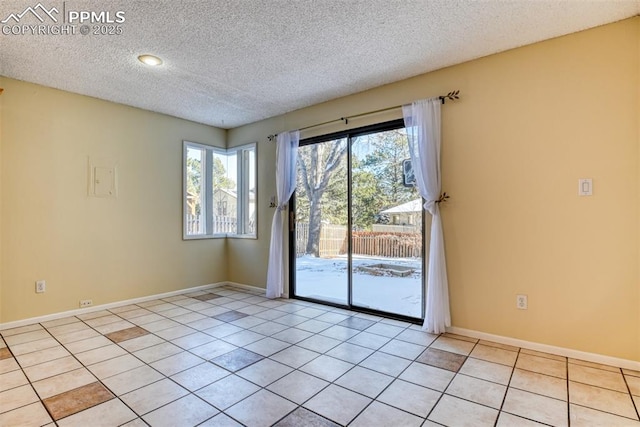 tiled empty room with a textured ceiling