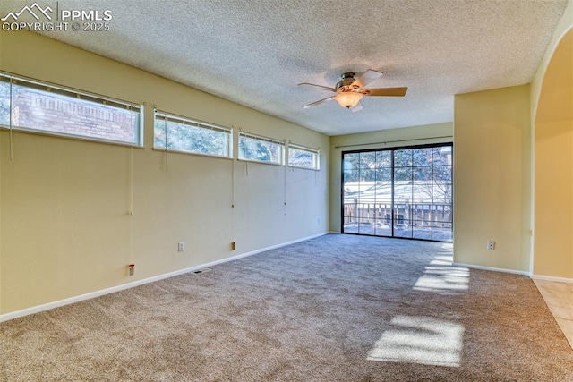 empty room featuring a textured ceiling, ceiling fan, and light carpet