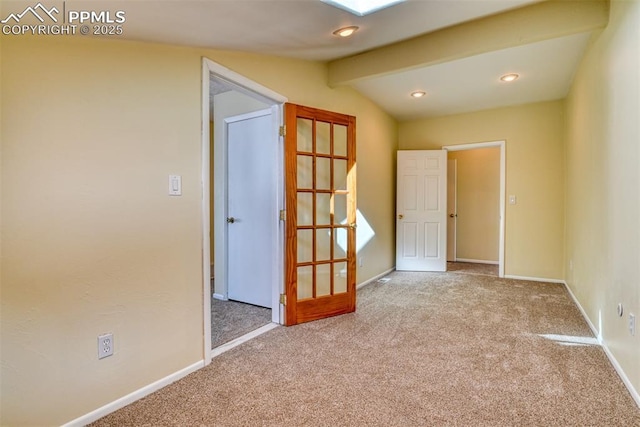 empty room featuring light colored carpet and vaulted ceiling