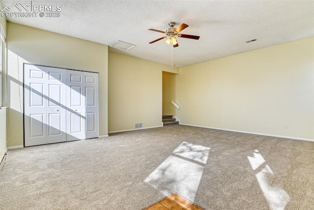 spare room with ceiling fan, carpet, and a textured ceiling