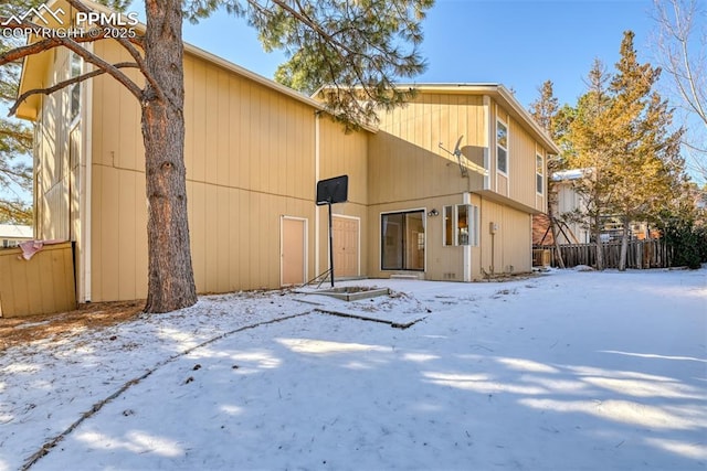 view of snow covered back of property