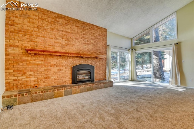 unfurnished living room with carpet, a fireplace, a textured ceiling, and high vaulted ceiling