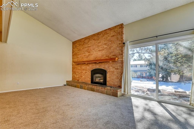 unfurnished living room with carpet, lofted ceiling, a textured ceiling, and a brick fireplace