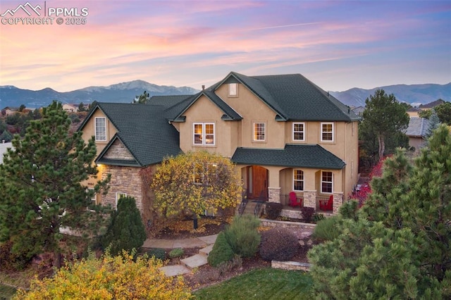 view of front of house with a yard, covered porch, and a mountain view