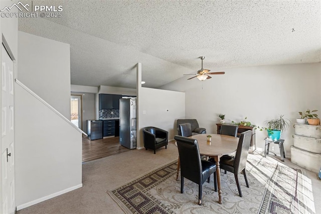 carpeted dining space with ceiling fan and lofted ceiling