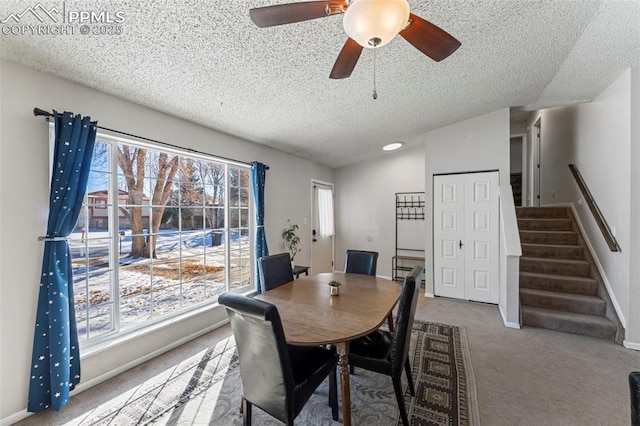 carpeted dining space featuring a textured ceiling and ceiling fan