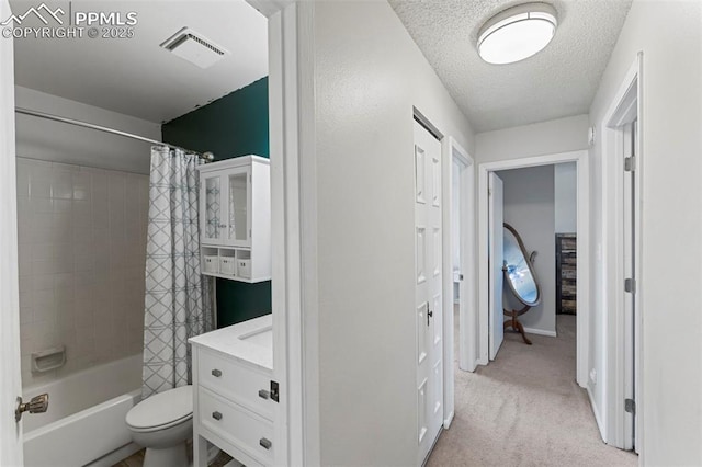 full bathroom with shower / bath combination with curtain, vanity, a textured ceiling, and toilet