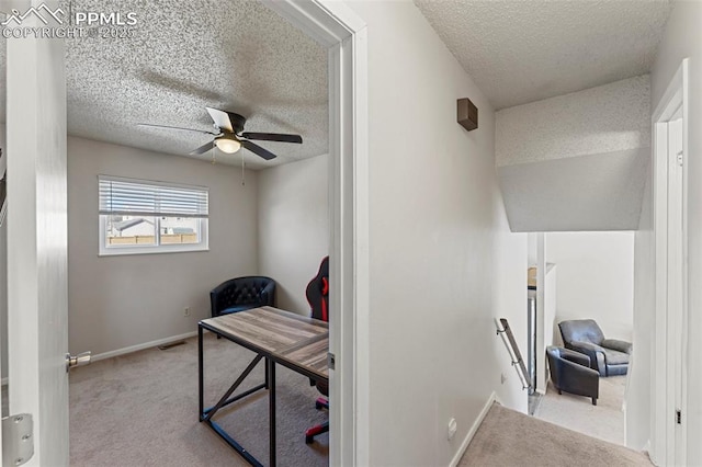 office with a textured ceiling, light colored carpet, and ceiling fan