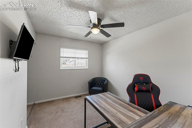 office space with ceiling fan, light colored carpet, and a textured ceiling