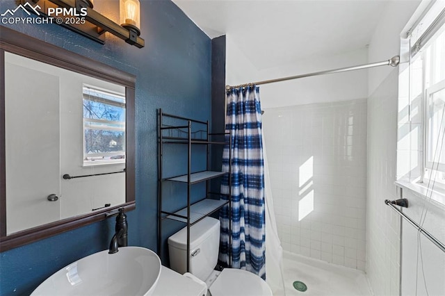 bathroom with a shower with curtain and toilet