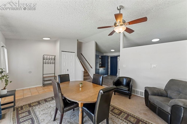 dining room with a textured ceiling, ceiling fan, lofted ceiling, and light tile patterned flooring