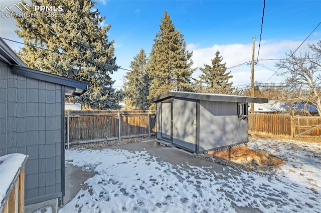 snowy yard featuring a storage unit