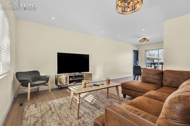 living room featuring a chandelier and light hardwood / wood-style flooring