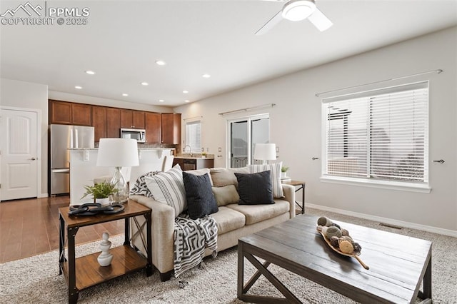 living room featuring ceiling fan and sink