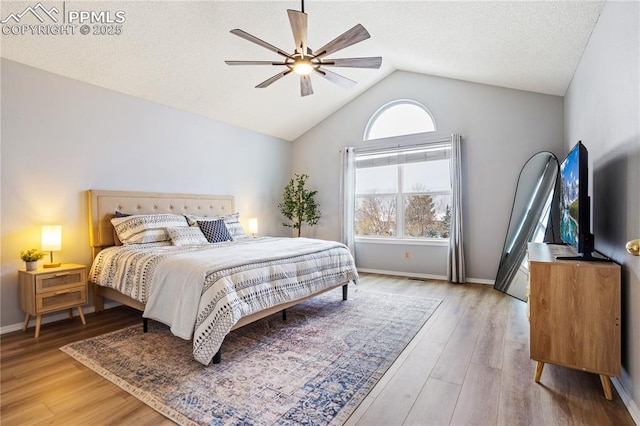 bedroom with multiple windows, ceiling fan, vaulted ceiling, and hardwood / wood-style flooring