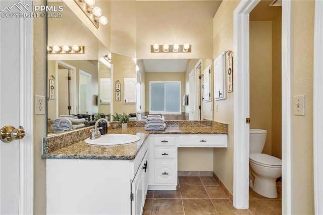 bathroom with tile patterned flooring, vanity, and toilet