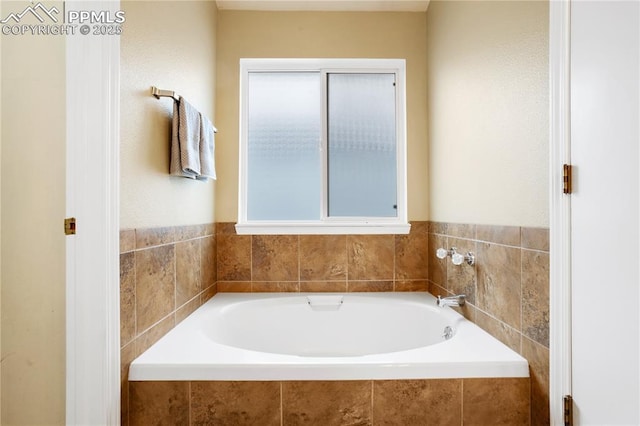 bathroom featuring plenty of natural light and a relaxing tiled tub