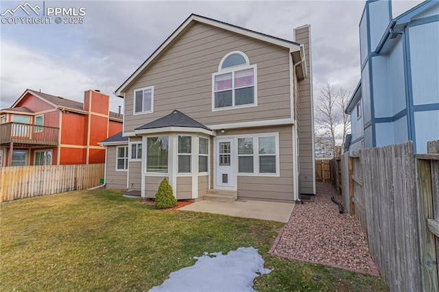 rear view of house with a yard and a patio