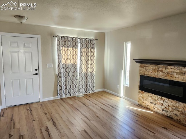 interior space featuring light hardwood / wood-style floors and a stone fireplace