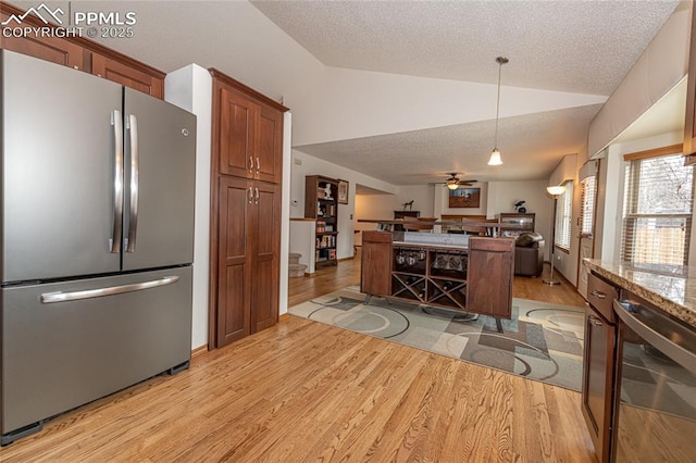 kitchen with stainless steel fridge, light stone counters, beverage cooler, ceiling fan, and lofted ceiling