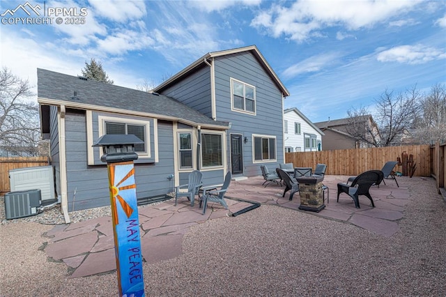 rear view of house with a fire pit, cooling unit, and a patio area