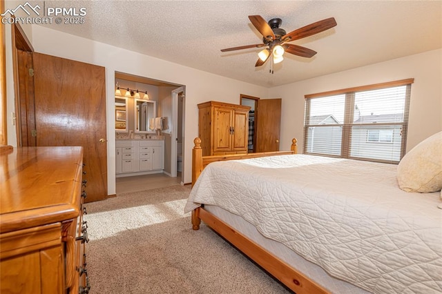 bedroom with light carpet, a textured ceiling, connected bathroom, and ceiling fan