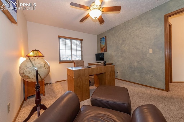 home office featuring light carpet, ceiling fan, and a textured ceiling