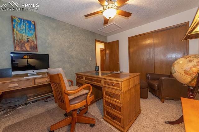 home office featuring ceiling fan, a textured ceiling, and light carpet