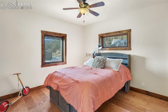 bedroom featuring wood finished floors, a ceiling fan, and baseboards