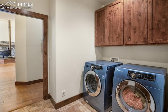 laundry room with washer and dryer, cabinet space, baseboards, and wood finished floors