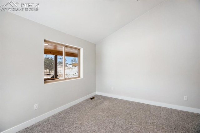 unfurnished room with carpet flooring and vaulted ceiling