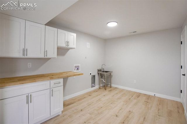 laundry area featuring light hardwood / wood-style floors, hookup for a washing machine, cabinets, and hookup for an electric dryer