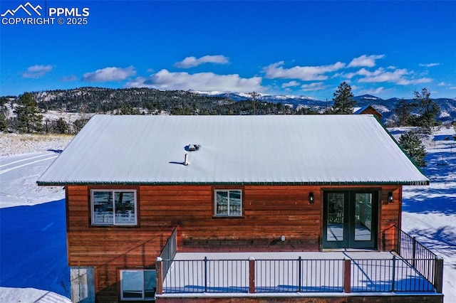 view of snowy exterior featuring a mountain view and french doors