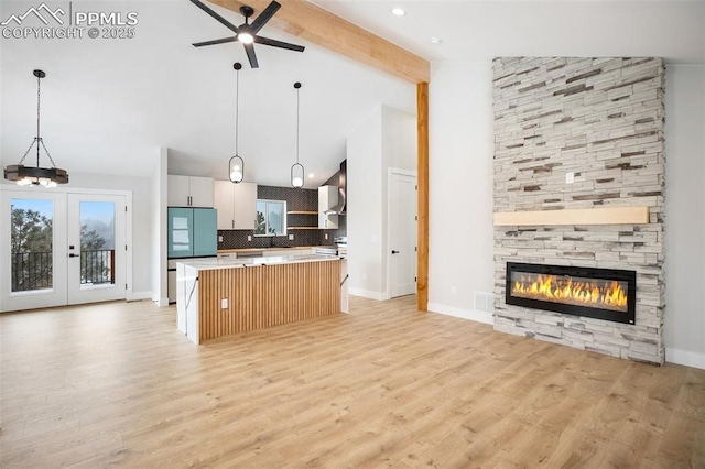 kitchen with a fireplace, tasteful backsplash, beamed ceiling, decorative light fixtures, and a kitchen island