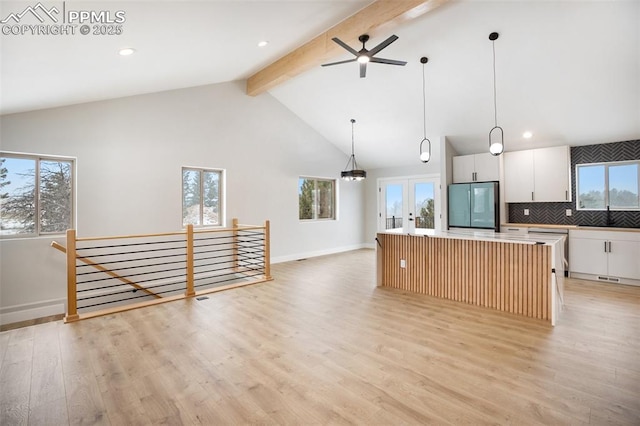 kitchen featuring a kitchen island, stainless steel fridge, pendant lighting, decorative backsplash, and white cabinets