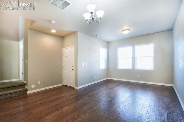 unfurnished room with dark hardwood / wood-style flooring and an inviting chandelier