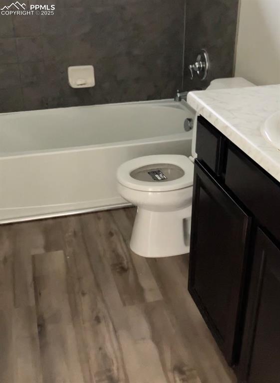 bathroom featuring wood-type flooring, toilet, and vanity