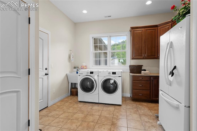 laundry room with washing machine and dryer and light tile patterned floors