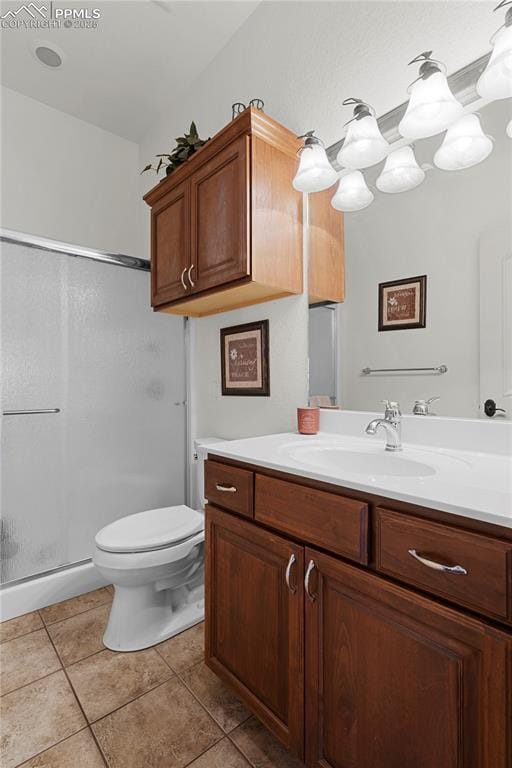 bathroom featuring tile patterned floors, vanity, toilet, and an enclosed shower