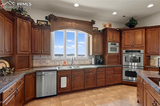 kitchen with sink, light tile patterned floors, stainless steel appliances, and tasteful backsplash