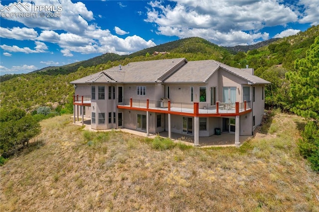 back of property with a patio area and a mountain view