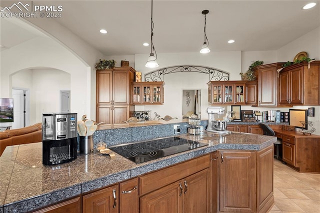 kitchen featuring black electric stovetop, decorative light fixtures, and light tile patterned floors