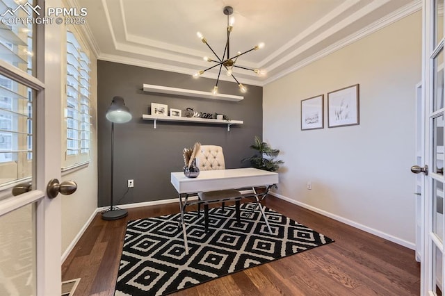 home office with dark wood-type flooring, a tray ceiling, a chandelier, and ornamental molding