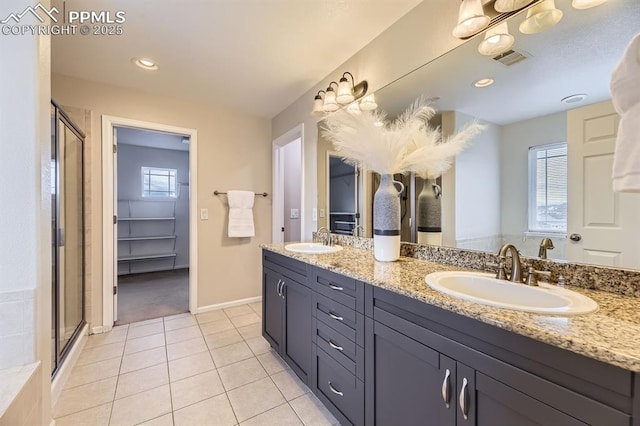 bathroom with a healthy amount of sunlight, tile patterned flooring, vanity, and a shower with shower door