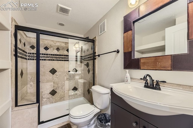 bathroom with toilet, vanity, a textured ceiling, and walk in shower