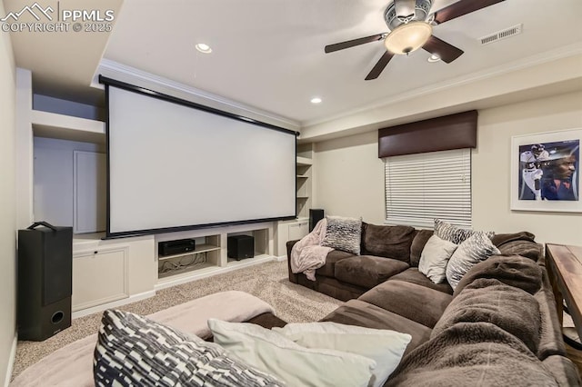 cinema with light carpet, built in features, ceiling fan, and ornamental molding