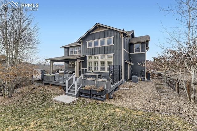 back of property with central AC unit, a lawn, and a wooden deck