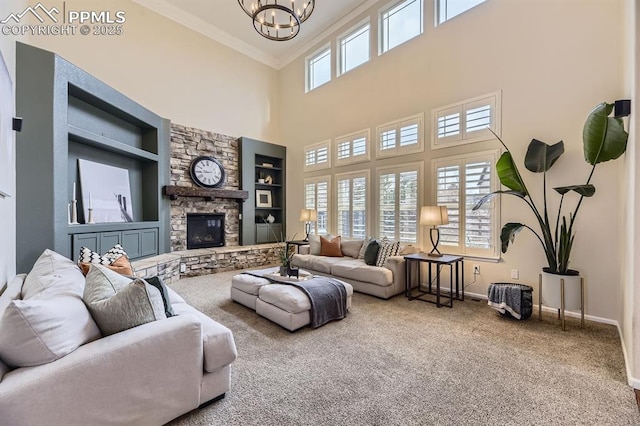 living room featuring an inviting chandelier, crown molding, carpet flooring, built in shelves, and a fireplace