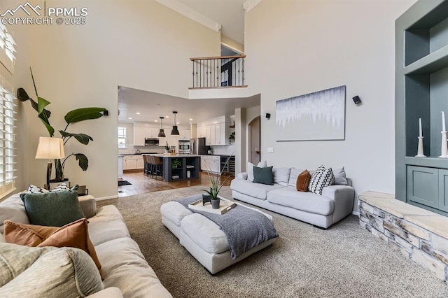 living room featuring carpet flooring, crown molding, and a high ceiling